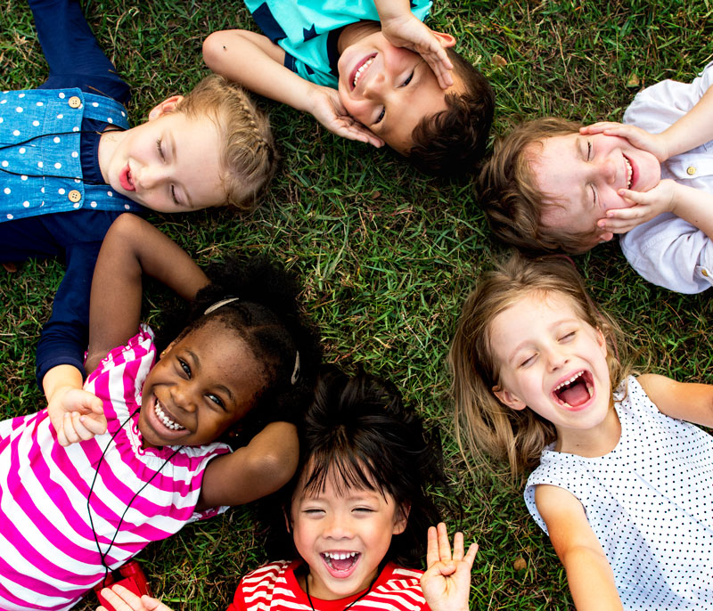 children laying on ground in a circle